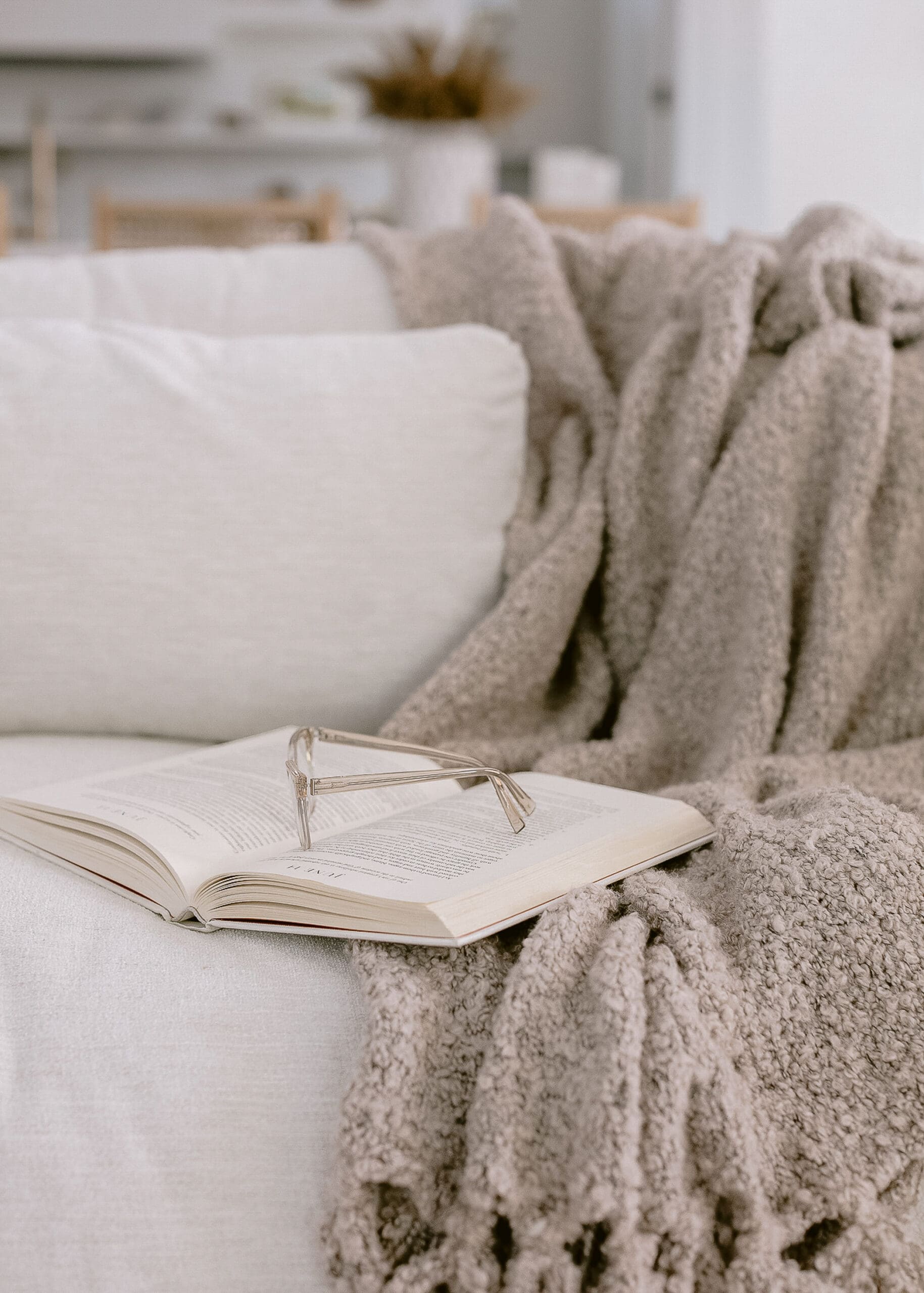 A comfortable couch with throw blanket and planner