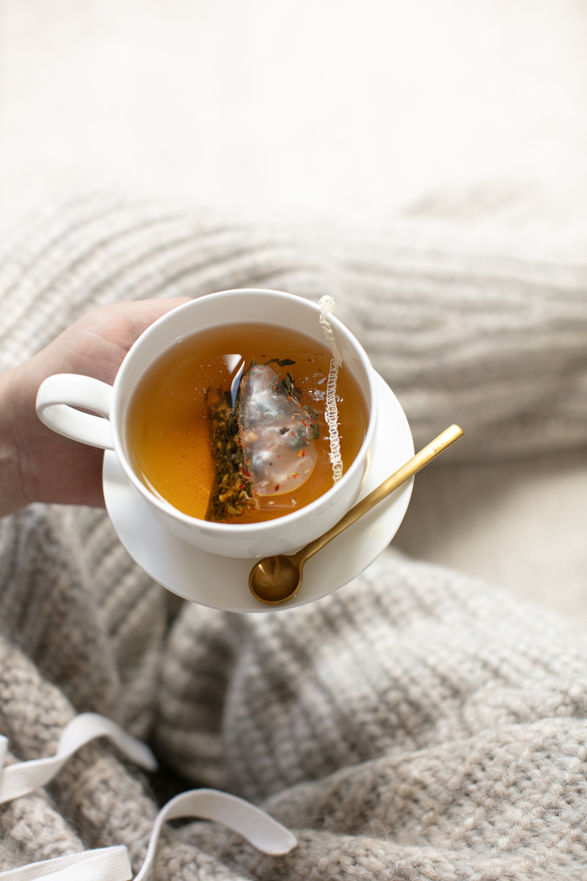 Chamomile herbal tea brewing in white cup with mesh tea infuser for natural anxiety relief
